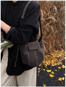 Detail of vintage bucket bag with contrast stitching in an autumn outdoor setting