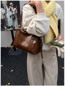 Detail view of a vintage brown leather tote bag with silver buckle and street style vibe