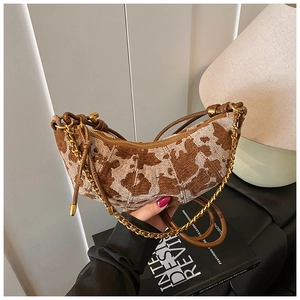 Detail of hobo bag featuring brown jacquard animal pattern and gold chain strap