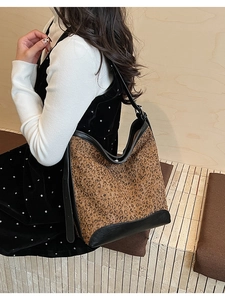 Detailed side view of large leopard print hobo bag with black leather stitching on model