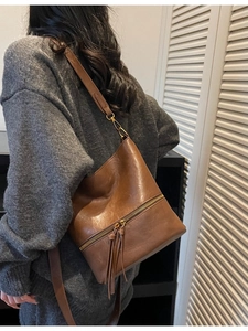 Sac seau vintage marron en cuir avec fermeture éclair dorée et longs glands