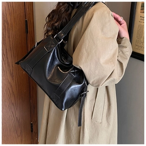 Detail of vintage black leather tote bag with cross-stitch square reinforcement and wide strap