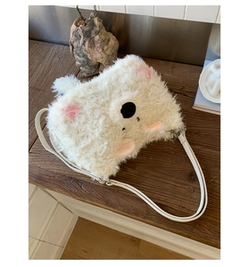 Detail of cute white plush animal bag with soft faux fur and adjustable leather strap