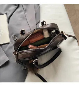 Draufsicht auf den geräumigen Innenraum der braunen Ledertasche mit Alltagsgegenständen