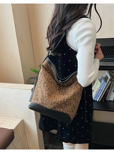 Detail of leopard print hobo bucket bag with leather trim and wide shoulder strap
