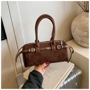 Close-up of a vintage brown suede Boston bag with strap buckle and rolled handles