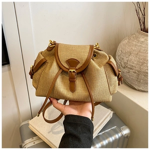 Detail of vintage woven shoulder bag with brown leather trim and gold buckle closure