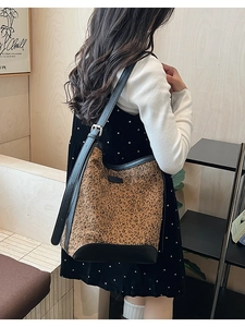 Detail of leopard print hobo bucket bag with black leather strap and vintage buckle