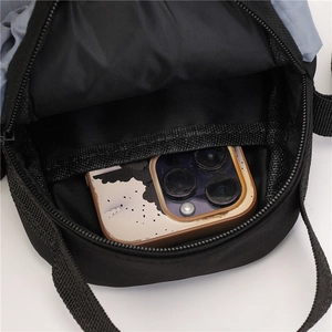 Detailweergave van de zwarte nylon crossbodytas met binnenvak voor een smartphone