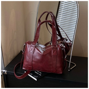 Detail of burgundy vintage tote bag with PU leather texture and detachable shoulder strap