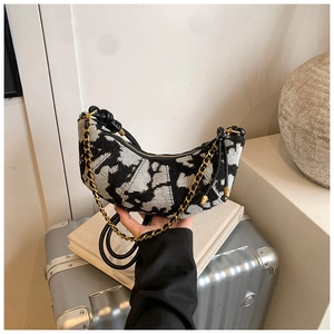 Macro shot of hobo bag featuring black and white jacquard fabric and gold chain hardware