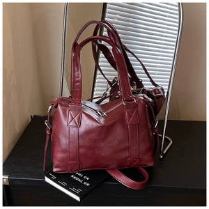 Detail of burgundy vintage leather tote bag with silver zipper and reinforced stitching