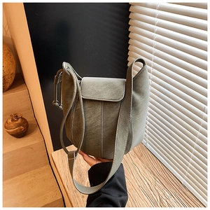 Detail of sage green bucket bag with contrast stitching and fine leather texture