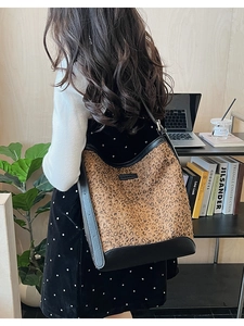 Rear view of a leopard print bucket bag styled with a professional autumn outfit