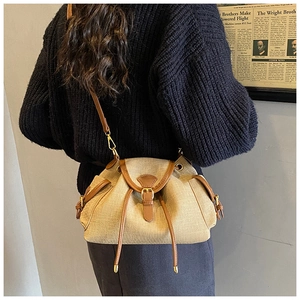 Detail of vintage canvas bucket bag with brown leather trim and drawstring closure