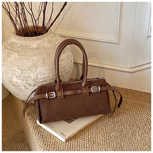 Detail of dark brown vintage suede leopard pillow bag with metallic buckle decorations