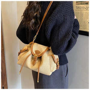Close-up of retro drawstring bucket bag featuring woven oatmeal fabric and brown leather trim