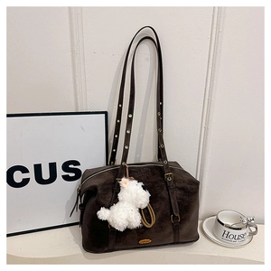Detailed macro view of dark brown suede texture and golden metal buckle on the shoulder bag