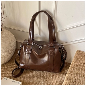 Detail of dark brown vintage Boston bag with glossy finish and silver zipper closure