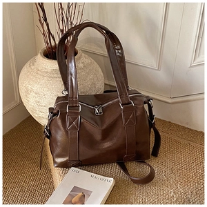 Close-up of dark brown PU leather tote bag with fine stitching and silver hardware detail