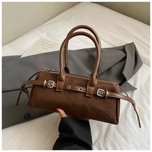 Detail of vintage brown suede boston bag with silver metal buckles and double top handles