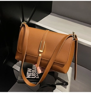 Detailed view of brown litchi grain leather bag with vintage golden metal buckle