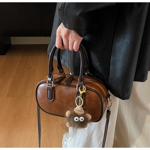 Braune Bowling-Tasche aus Leder mit niedlichem Plüsch-Monster-Anhänger und Schultergurt