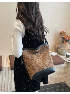 Detailed close-up of leopard print bucket bag with black leather trim in cafe setting