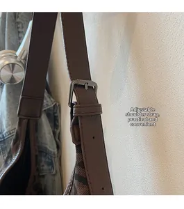 Detail of adjustable brown leather shoulder strap with silver buckle on leopard print bag