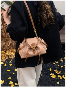 Brown woven texture crossbody bucket bag with drawstring detail shown on model