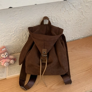 Detail view of dark brown faux suede backpack featuring cute rabbit ear hood and buckle closure