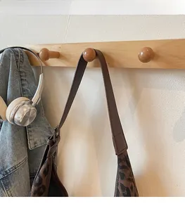 Close-up of leopard print shoulder bag with comfortable adjustable brown leather strap