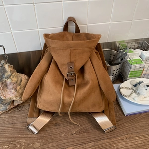 Detailed view of caramel suede backpack with rabbit ears and golden strap buckles