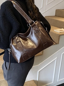 Deep brown glossy leather tote bag for women shown from a stylish side view profile