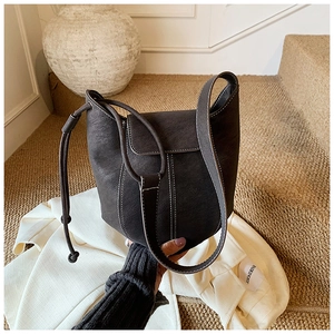 Detail of dark taupe leather bag with contrast white stitching and flap closure
