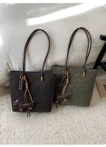Detail of retro matte tote bags in dark coffee and olive green with dog pendants