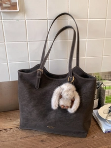 Vintage dark brown tote bag with contrast stitching and plush rabbit keychain accessory