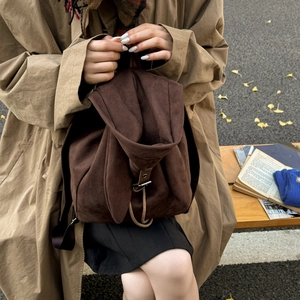 Macro shot of dark brown suede backpack with bunny ear design and drawstring closure