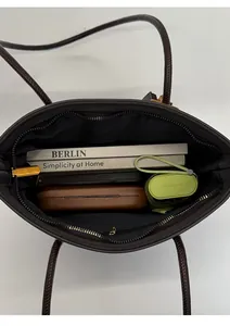 Top view of spacious interior of brown leather tote bag with pocket and daily essentials