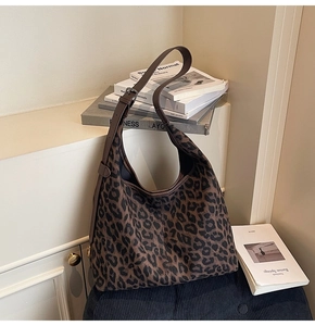 Detail of adjustable leather strap and buckle on a large leopard print tote bag