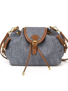Minimalist grey canvas bucket bag with brown leather trim and drawstring closure