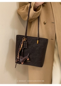 Detailed macro of dark brown textured leather tote with fashion gold lettering