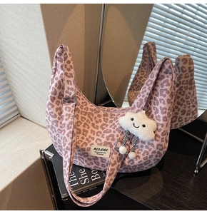 Close-up of pink leopard print canvas tote with MULAIDI label and plush cloud charm