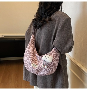 Pink leopard print tote bag with white plush cloud charm shown on shoulder