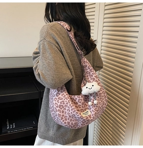 Detail of pink leopard print tote bag with plush cloud charm on a wide shoulder strap