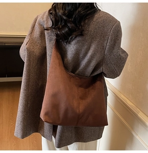 Detail of dark brown matte suede hobo bag showing large capacity and soft texture