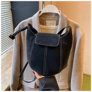 Detail of black bucket bag with contrast stitching and adjustable knot shoulder strap