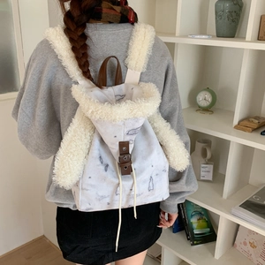 Detailed close-up of marble pattern canvas and soft faux shearling trim on the backpack