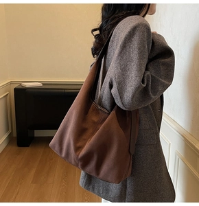 Macro shot of dark brown matte tote bag with adjustable leather shoulder strap detail