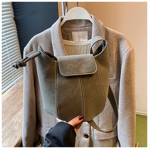 Detailed view of olive green bucket bag with lychee texture leather and contrast stitching